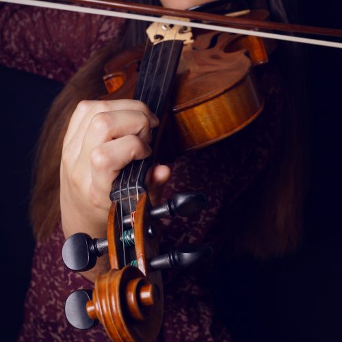 close-up of young asian woman playing violin with selective focus