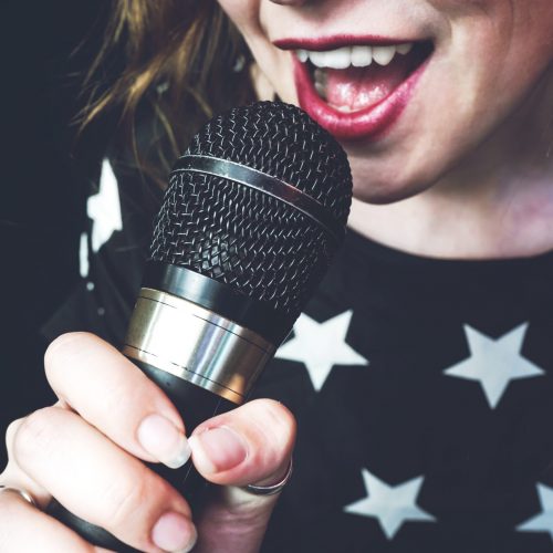 Young woman singing a song with a microphone